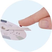 Immagine del dito indice mentre versa una goccia di sangue sul disco del test