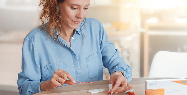 sediaci žena pri stole si robí domáci test Veroval