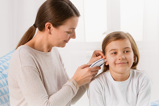 Moeder meet temperatuur bij dochter