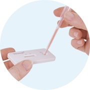 Dos dedos introduciendo la muestra dentro del dispositivo de test