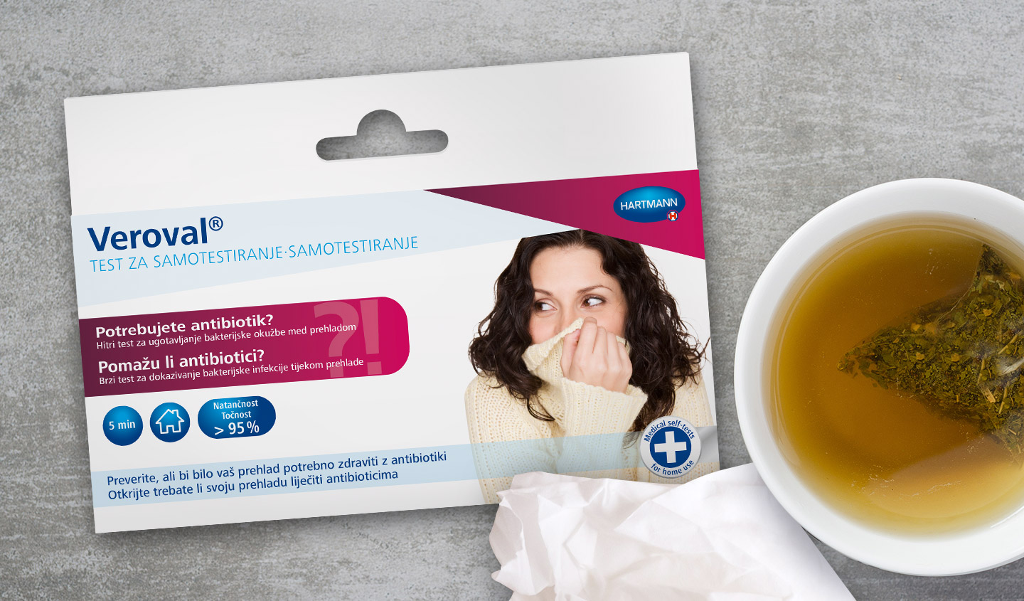 Die Verpackung eines Veroval Selbst-Tests "Helfen Antibiotika" liegt neben einer Tasse Tee
