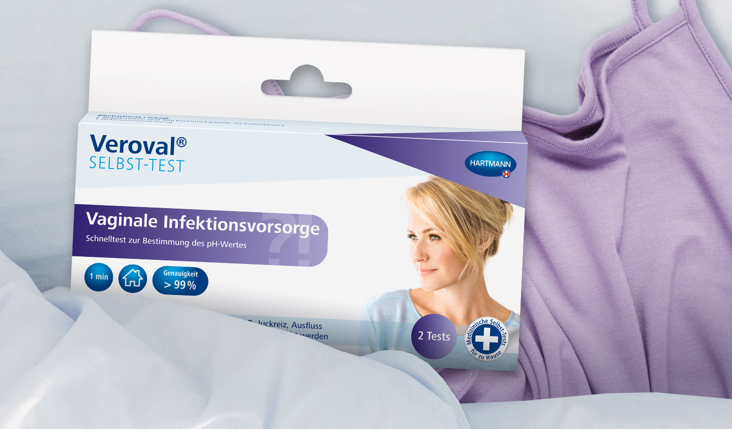 Eine Verpackung des Veroval Selbst-Test Vagiale Infektionsvorsorge liegt auf einem lilanen Frauenoberteil.