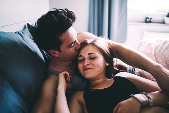 Jong stel knuffelend op de bank